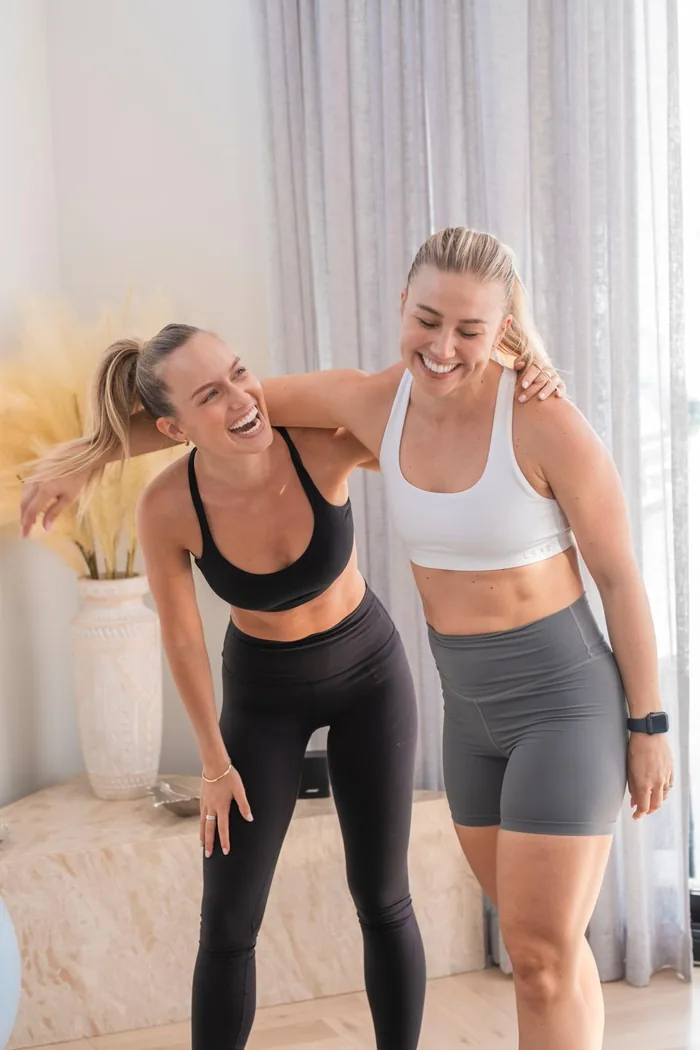 Two women laughing together mid-session in the studio